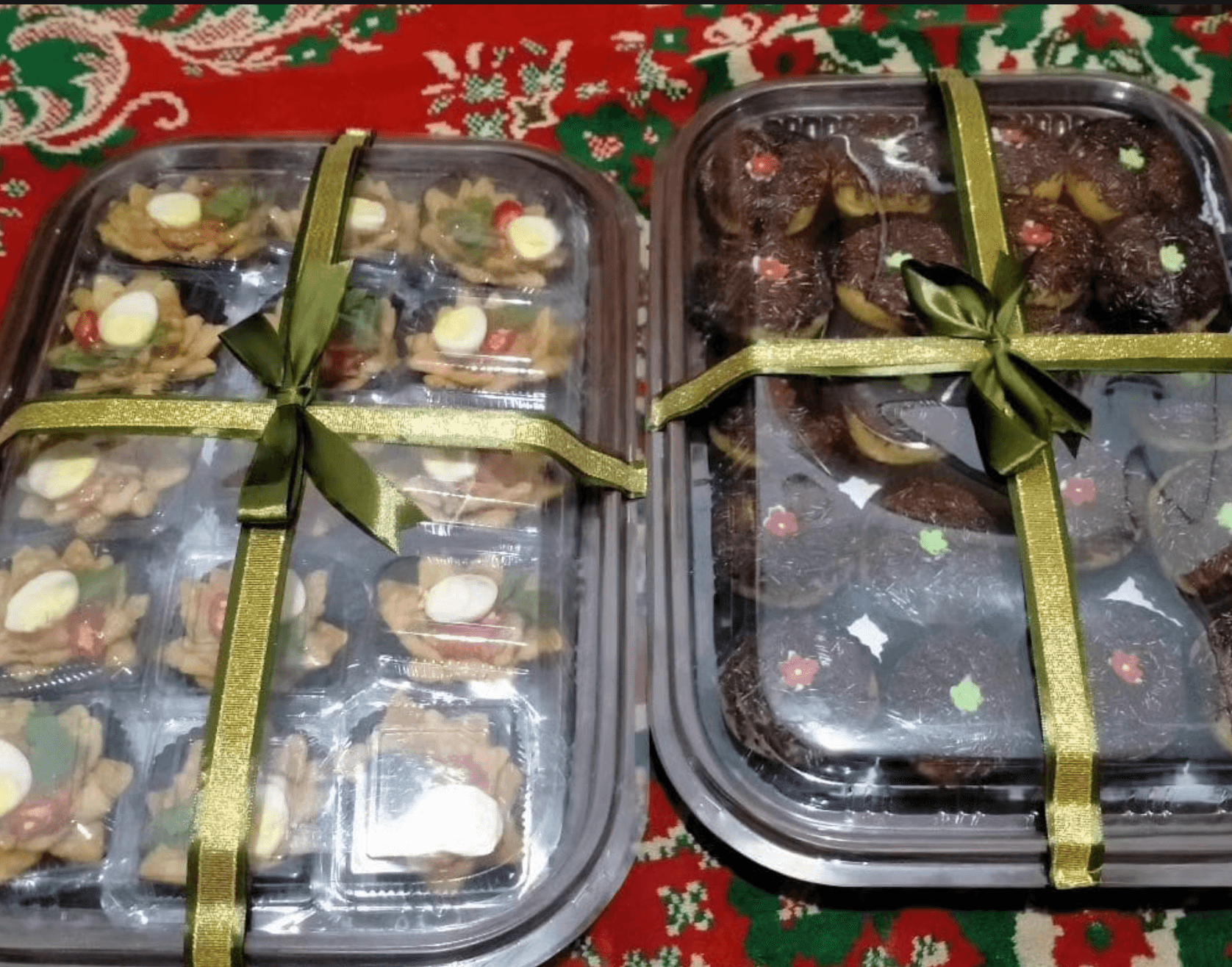 Dua kotak hantaran berisi kue kering dan camilan, dihias dengan pita emas