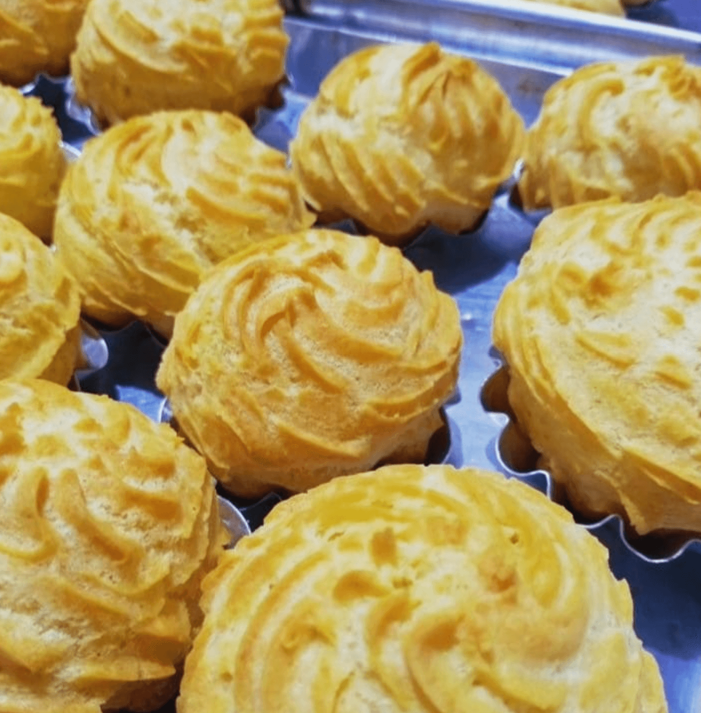 Soes atau choux pastry berisi vla, disusun rapi di atas loyang