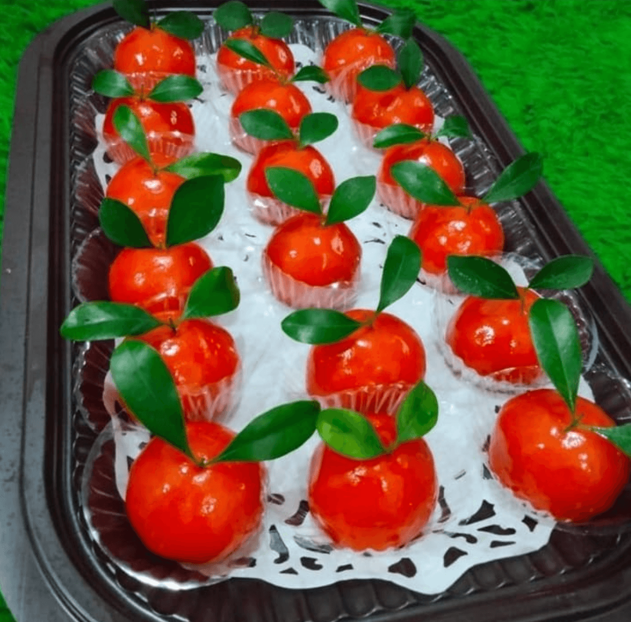 Kue tok berbentuk dan berwarna seperti jeruk mandarin lengkap dengan daun