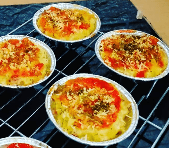 Macaroni schotel panggang dalam cup foil dengan topping keju dan saus tomat